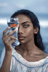 Close-up portrait of a young woman drinking glass