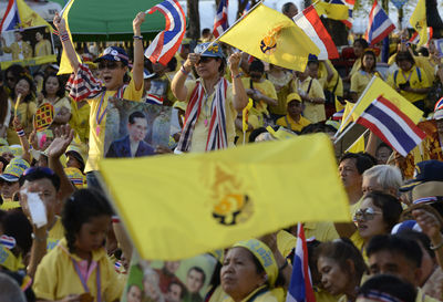 High angle view of people with picture frame and thai flags at event