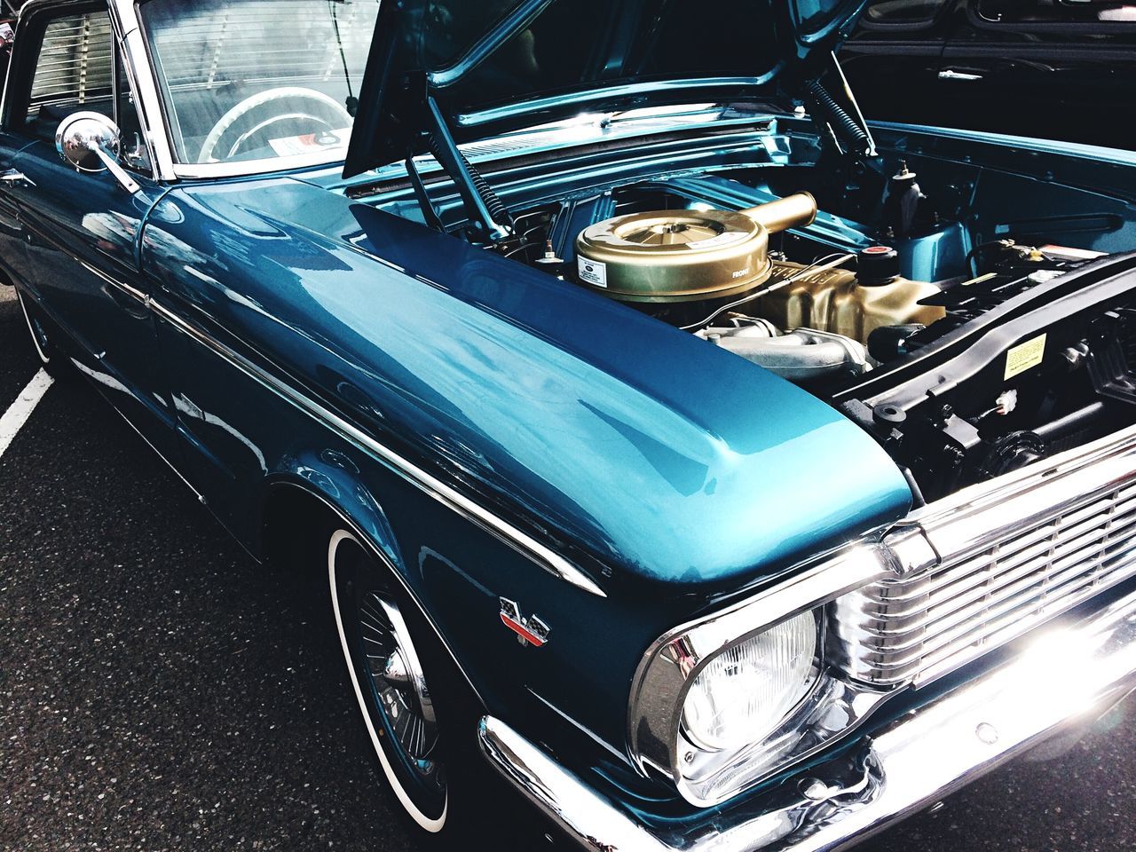 transportation, mode of transportation, car, land vehicle, motor vehicle, vintage car, metal, retro styled, day, engine, blue, stationary, no people, high angle view, vehicle hood, shiny, outdoors, silver colored, chrome, luxury