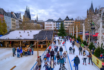 Group of people in traditional building against sky in city