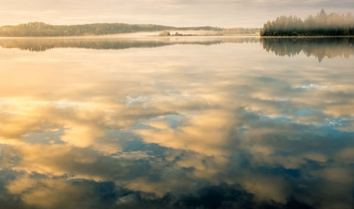 Scenic view of lake against sky at sunset