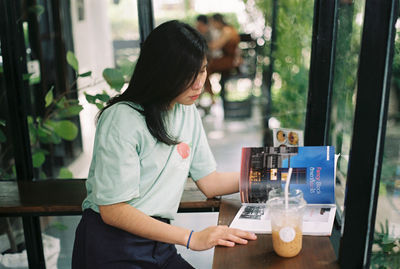 Midsection of woman sitting at restaurant table