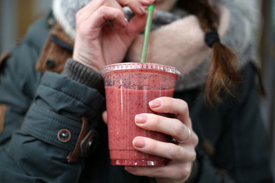 Midsection of woman having smoothie