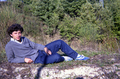 Portrait of a young man sitting on plants