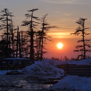 Scenic view of snow covered landscape at sunset