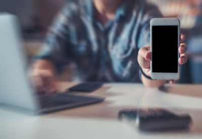 Midsection of woman using mobile phone