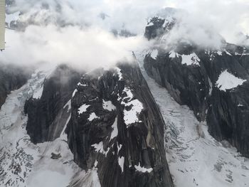 Panoramic view of snow covered mountains against sky