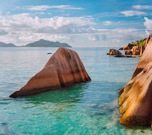 Scenic view of rocks in sea against sky