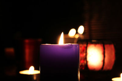 Close-up of burning candle in darkroom