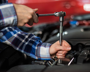 Midsection of man repairing car