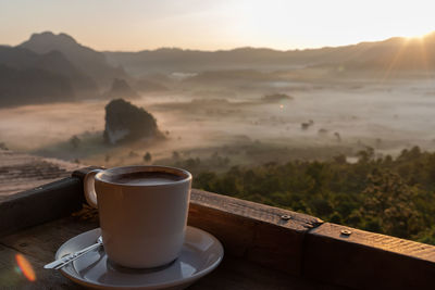 Sunrise with cup of hot cocoa at phu lang ka , phayao, thailand.