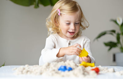 Portrait of cute girl playing with toys at home