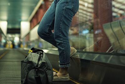 Low section of man walking on airport