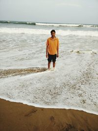 Young man standing on shore at beach