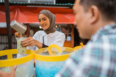 Close-up of young woman holding drink