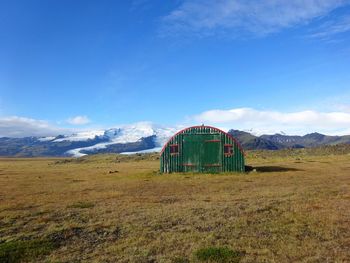 Built structure on field against blue sky