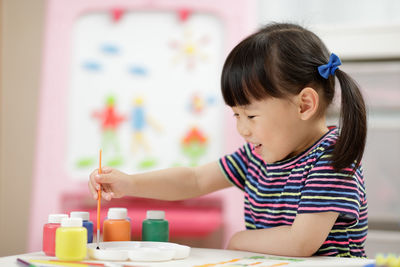 Cheerful girl painting at home