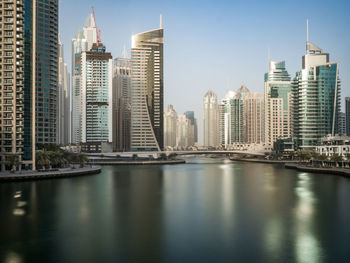 River by buildings against sky in city