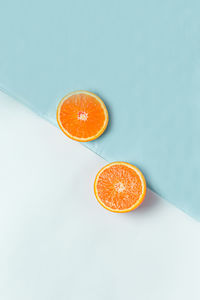 High angle view of orange slice against blue background