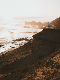 Man standing on beach against clear sky