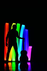 Silhouette man with multi colored lights