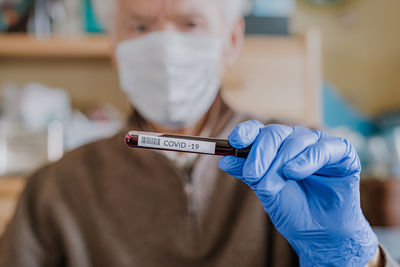 Midsection of man holding test tube