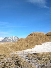 Scenic view of snowcapped mountains against blue sky