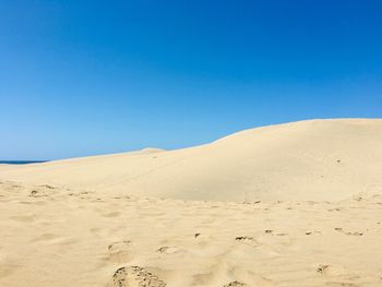 Scenic view of desert against clear blue sky