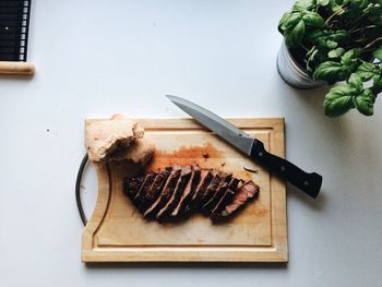 Directly above shot of sliced beef steaks and knife on cutting board