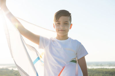 Portrait of boy standing against sky