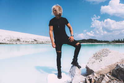 Man standing by lake against sky