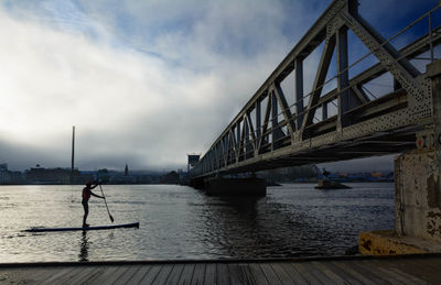 Man on bridge against sky