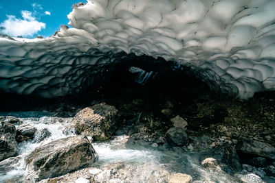 Rock formation in sea against sky