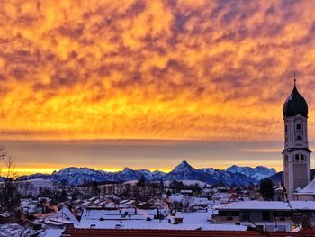 Panoramic view of church against cloudy sky during sunset
