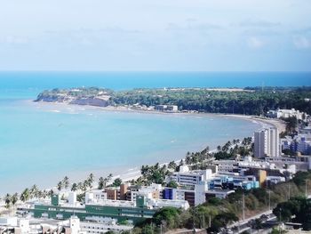 High angle view of city by sea against sky