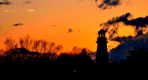 Silhouette lighthouse against sky during sunset