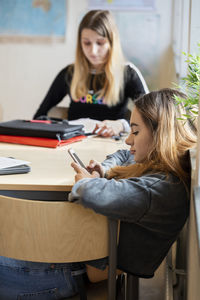 Teenage girl in classroom using phone