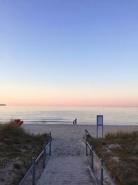 Footbridge leading to beach with people in distant