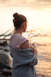 Woman looking at sea during sunset