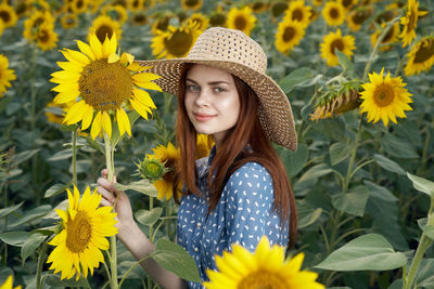 Portrait of woman standing amidst yellow flowering plants