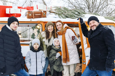 Portrait of smiling friends standing on snow