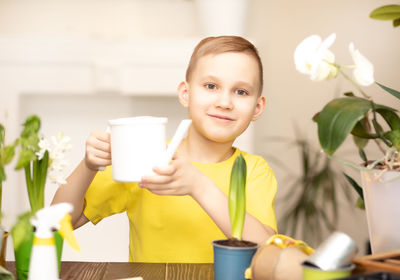 Portrait of cute girl using mobile phone on table