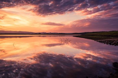 Scenic view of lake against romantic sky at sunset