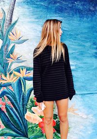 Woman standing against graffiti on wall