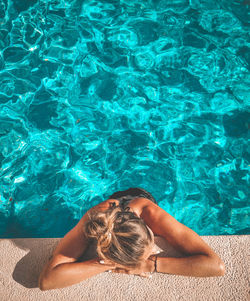 High angle view of woman relaxing in swimming pool