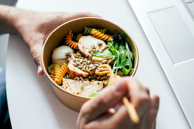 Cropped hand of person having food in bowl