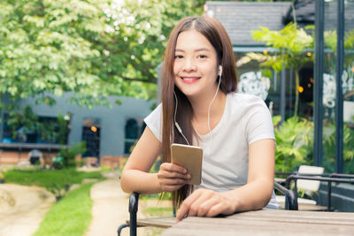 Young woman using mobile phone in park