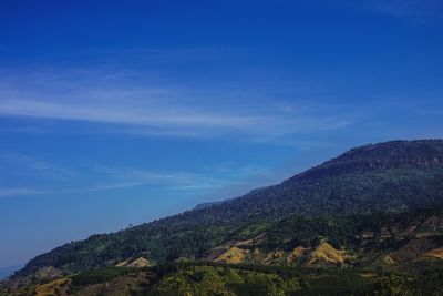 Scenic view of mountains against blue sky