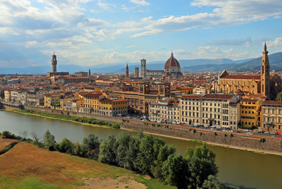 River amidst buildings in city against sky