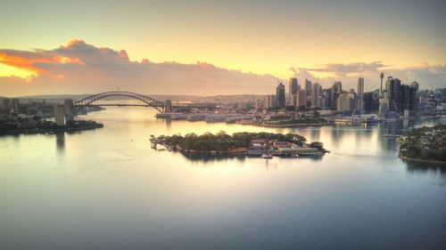 Bridge over river in city during sunset
